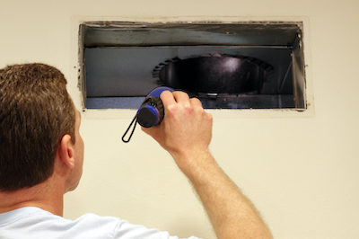 man looking into blocked ac vents