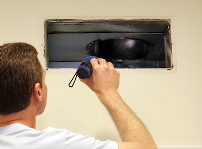 man looking into blocked ac vents